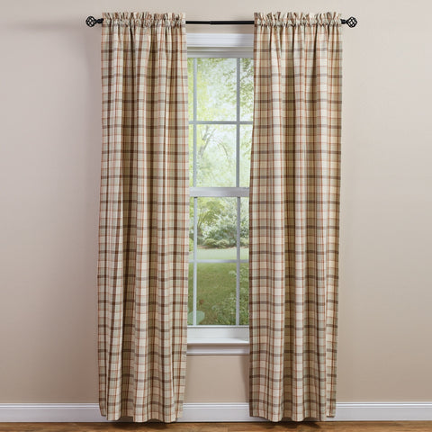 Toffee & Elm Plaid Long Panel Curtains 84" A pair of beige green and brown plaid curtain panels hanging on a black rod over a window, with a light beige wall and a view of greenery outside.