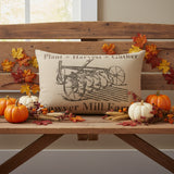 Farmstead Charcoal Plow Harvest Throw Pillow 22x14 styled on a wood bench in a farmhouse living room with fall decor