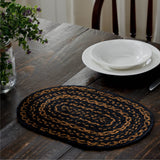 Blackstone Farm Braided Oval Placemat Set of 6 –10x15 – Black and Tan Jute on a dark wood dining table, styled with a white bowl and plate, silverware, and plant arrangement with a wooden chair.