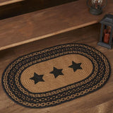 Blackstone Farm Star braided oval rug in black and tan jute — close-up of stenciled black 5-point star detail on tan braid at base of wood staircase