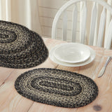 Farmstead Black Braided Placemat - Set of 6 on a wooden table with white plates and cutlery.