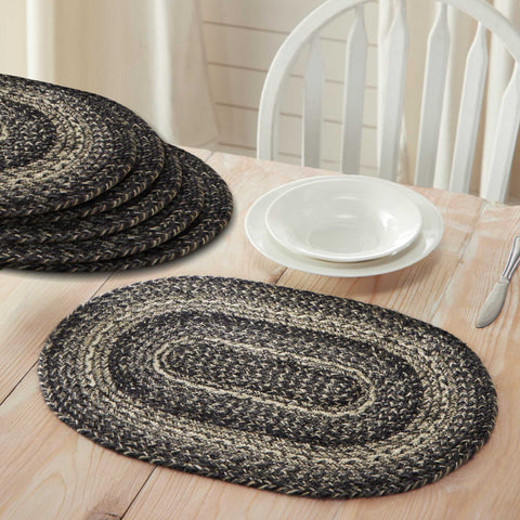 Black and cream Farmstead Black Braided Placemat - Set of 6 on a wooden table with white plates and cutlery.