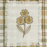 Sage & Mustard Plaid Dishtowel Embroidered floral design on a white fabric square with frayed edges, placed on a plaid background.
