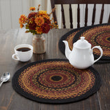 Heirloom Farm Braided Trivet 15" Set of 3 styled on dark farmhouse wood dining table with white teapot, coffee cup, and fall floral arrangement