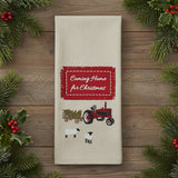 Beige towel with red 'Coming Home for Christmas' label, tractor, and sheep design on a white background