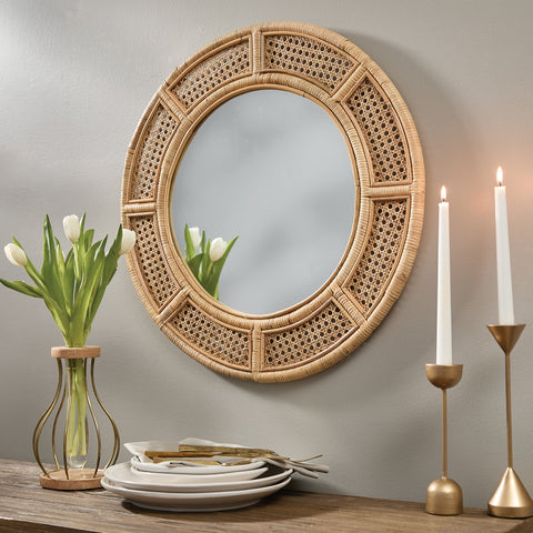 Rattan Round Mirror on a wall with decorative items including tulips, plates, and candles.