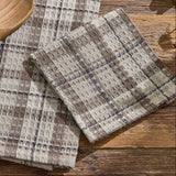 Tinderbox Brown Plaid Dishcloths arranged on a rustic wood farmhouse surface with a wooden spoon — 100% cotton waffle weave dishcloths in brown and oatmeal plaid, set of 3