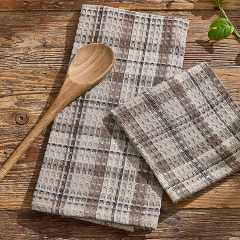 Tinderbox Brown Plaid Waffle Dishtowels layered on a rustic wood surface with a wooden spoon and fresh basil — set of 2 waffle weave 100% cotton dishtowels in tinderbox brown, oatmeal and espresso plaid