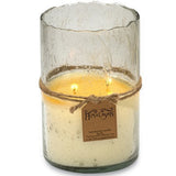 Artisan Clear Bubble Glass Hurricane Hand-Poured Soy Scented Candle A two-wick candle in a clear, textured glass jar with a warm yellow wax fill, wrapped in a rustic brown twine band with a hanging paper tag that reads Himalayan.