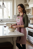 Woman wearing the Wine and Dine Chef Apron in a kitchen